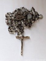 Rosary coiled showing beads, centerpiece and crucifix