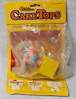 Front of sealed Wilton Cake Tops package showing clown in yellow box