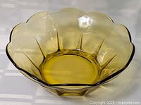 Full view of yellow glass fruit bowl interior and scalloped rim