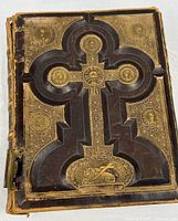 Front cover showing raised cross and gilt decoration