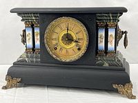 Full front view of clock showing case, dial, porcelain panels, brass feet
