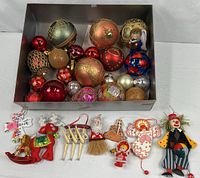 Overview of box with glass ornaments and separate wooden and resin ornaments in front