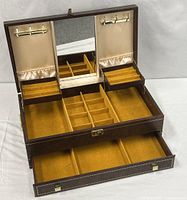 Jewelry box open showing mirror, interior compartments, swing-out trays, lower drawer