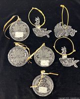 Seven Mikasa crystal ornaments laid out on black background