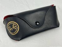 Full view of closed black Ray-Ban case showing logo and snap