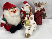 Group shot of three Santas and angel decor on table