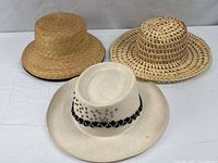 Three sun hats: ivory Eddy Bros with embellishments, natural open-weave hat, tan Ann Taylor hat