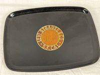 Front view of black Couroc serving tray with Levi Strauss & Co wood and brass inlay