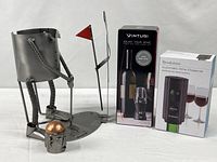 Overall lot showing steel wine holder sculpture, Vinturi aerator box, Brookstone preserver box