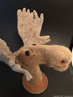 Front view of felt moose head on wood plaque