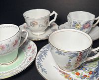 Group of four floral English teacups with saucers