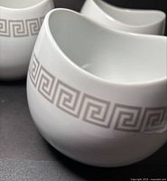 Three white porcelain bowls showing Greek key design and shape