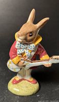 Front view of Royal Doulton Bunnykins Mr. Bunnybeat figurine showing details of rabbit with guitar