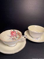 Two Paragon yellow teacups with saucers displayed