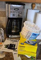 Full view of Cuisinart coffee maker, carafe, manual, two boxes and loose coffee filters