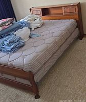 Full view of bed frame with mattress and bedding