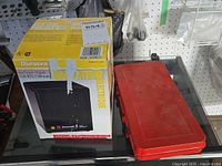 Duracraft heater retail box beside closed red metal socket case