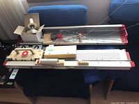 Full view of knitting machine with accessory box and needle bed