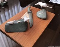 Overall view of three soapstone pieces on wooden board