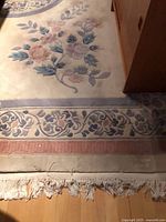 Corner showing floral vine border, fringe and wear