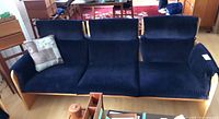 Front view of navy corduroy three-seat sofa with throw cushion