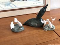 All three carvings displayed together on tabletop