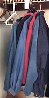 Row of five jackets hanging in closet, showing colors and styles