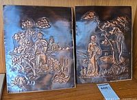 Front view of both embossed copper panels showing relief scenes and signatures