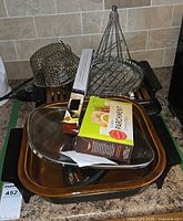 Lot overview showing skillet, glass lid, parchment paper box, racks on top of grill unit