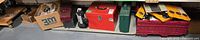 Wide view of dolly, boxes, flash­light, toolboxes and crate on shelf