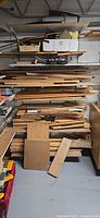 Shelving unit with large stack of mixed lumber offcuts and trim pieces