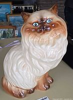 Front of glazed ceramic cat figurine showing face and body