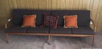 Front view of teak sofa with three throw cushions