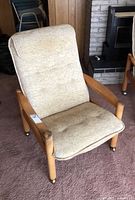 Full view of lounge chair showing wood frame, upholstery and casters