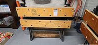 Front view of folding workbench showing wooden jaws, dog holes, metal frame