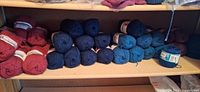 Shelf with red, navy, teal and brown skeins