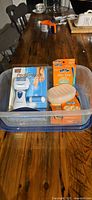 Entire lot inside plastic bin showing PediSmooth package, corn remover packs, soap holder