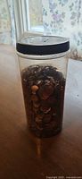 Full view of plastic jar filled with pennies