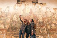 Visitors photographing and viewing historic murals inside ROM gallery