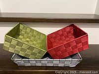 Three baskets stacked: green, red, grey