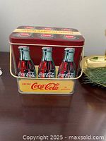 Front view of Coca-Cola tin showing handle and side graphic