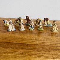 Group view of all ten Wade Red Rose Tea porcelain figurines on wooden surface