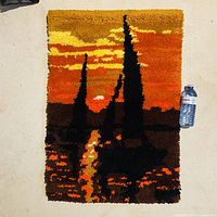 Front view of rug hooking showing full design and water bottle for scale