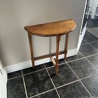 Front view of demilune table showing top shape and legs