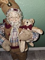 Front view of Santa figure holding teddy bear