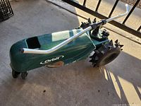 Left side view showing Orbit branding, body, wheels, and spray arm