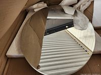 Front view of oval mirror inside packaging