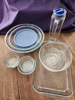 Group shot showing all glass items: Pyrex bowls, Marinex pan, Pasabahce pitcher, custard cups, handled bowl