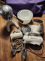 Group view of stand mixer base, two hand mixers, Juice King juicer, Pyrex bowls