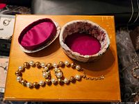 Necklace and open fabric box showing satin lining